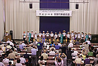 中山道533Kmウオーク完歩者を紹介する副隊長・野村副代表（左端演台）